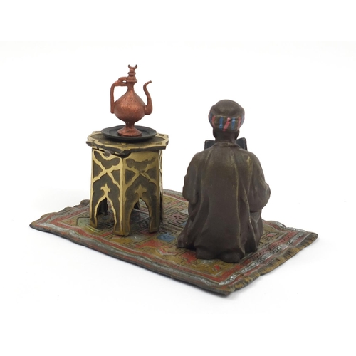 153 - Cold painted bronze of an Arab on a carpet in the style of Franz Xaver Bergmann, 14cm wide