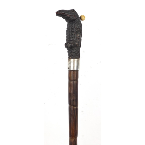 388 - Bamboo walking stick having silver collar and carved wood crocodile pommel with mechanical tongue an... 