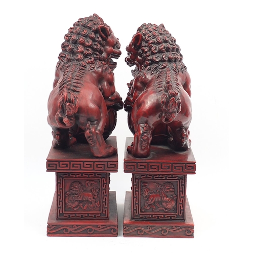 1190 - Large pair of Chinese red lacquered style Foo dogs, each 49.5cm high