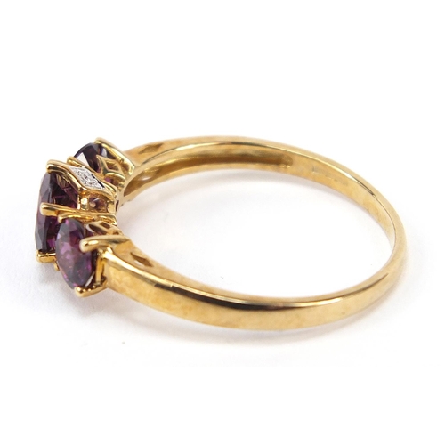 868 - 9ct gold purple stone trilogy ring, size U, 2.5g