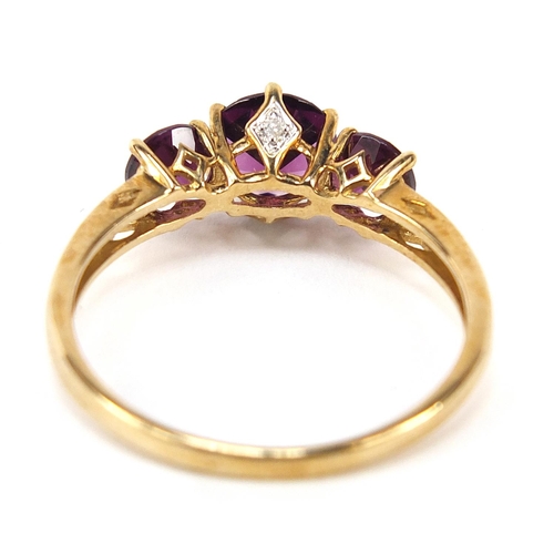 868 - 9ct gold purple stone trilogy ring, size U, 2.5g