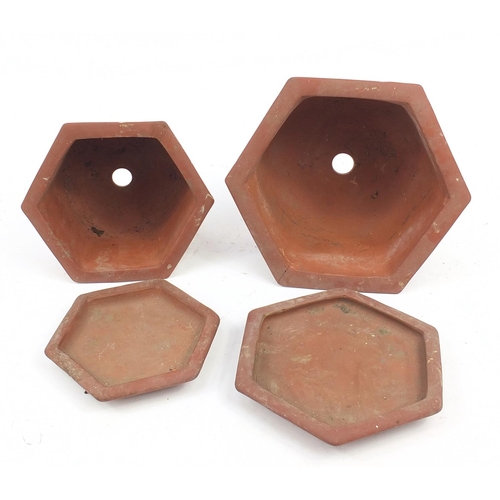 908 - Two Chinese Yixing terracotta hexagonal planters on stands decorated with calligraphy and trees, the... 