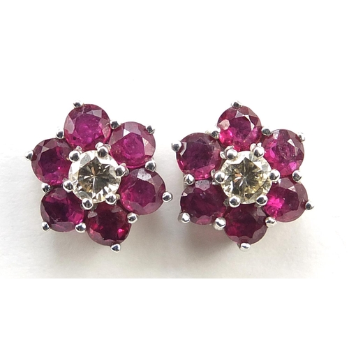 79 - Pair of 18ct white gold diamond and ruby flower head stud earrings, 10.8mm in diameter, 3.3g