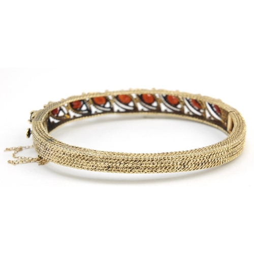 162 - 14ct gold garnet hinged bangle, 6.5cm wide, 22.0g