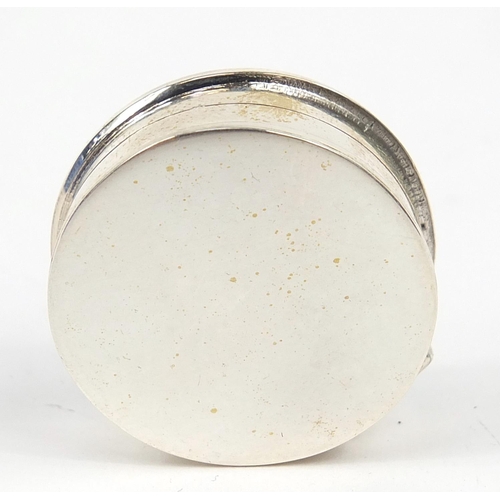 854 - Circular silver patch box, the hinged lid enamelled with a semi nude female, 2.7cm in diameter, 16.2... 