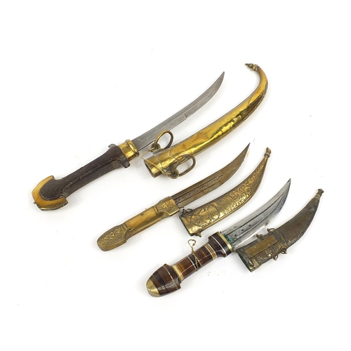 403 - Three Moroccan Koummya daggers with scabbards including one with segmented horn handle, another with... 