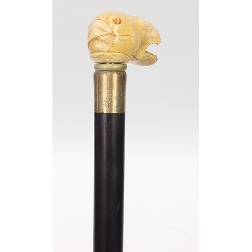 1133 - Hardwood walking stick with carved bone dog head design handle, 92cm in length