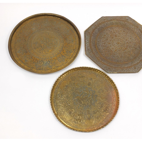 472 - Four good Indian brass trays comprising an octagonal example profusely and finely embossed with flow... 