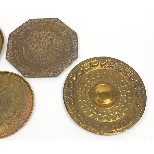 472 - Four good Indian brass trays comprising an octagonal example profusely and finely embossed with flow... 