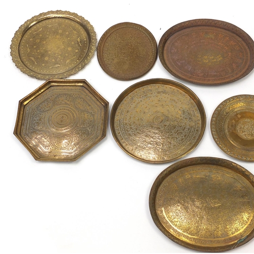 486 - Nine Indian copper trays embossed and engraved with wild animals and flowers, the largest 48cm wide