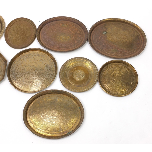 486 - Nine Indian copper trays embossed and engraved with wild animals and flowers, the largest 48cm wide