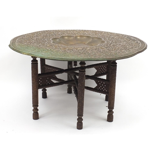 488 - Large Middle Eastern coppered brass tray top table embossed with foliage, 52cm high x 99cm in diamet... 