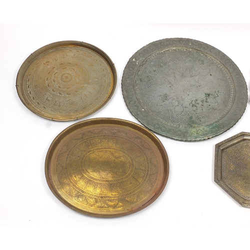 471 - Five Indian and Persian brass/copper trays including one profusely and finely embossed and pierced w... 