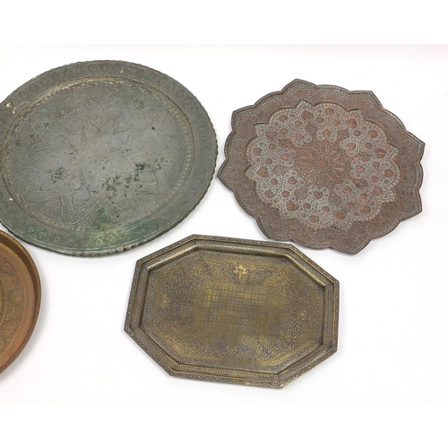 471 - Five Indian and Persian brass/copper trays including one profusely and finely embossed and pierced w... 