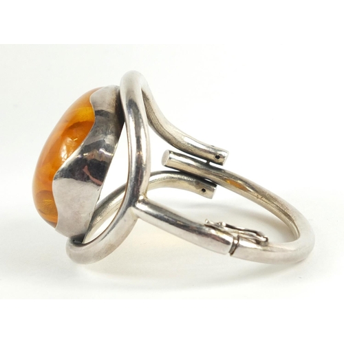 122 - Large unmarked silver and natural amber hinged bangle, 66.8g