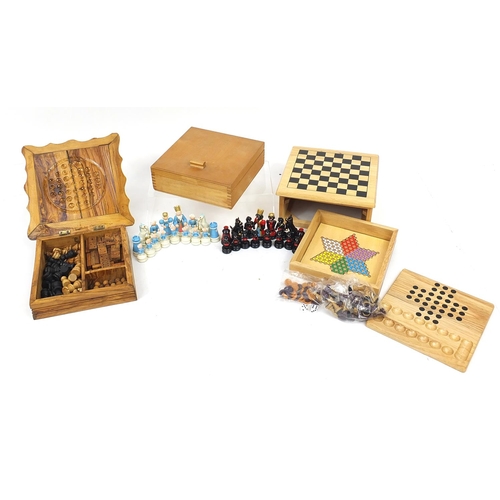 1243 - Two wooden games compendiums and a hand painted figural set, the largest 25cm wide