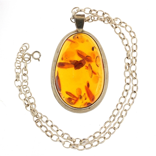 461 - Large silver and natural amber pendant on a silver necklace, the pendant 6cm high, total 45.2g