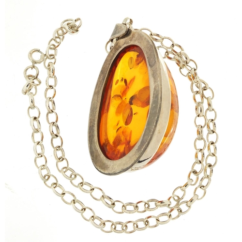 461 - Large silver and natural amber pendant on a silver necklace, the pendant 6cm high, total 45.2g