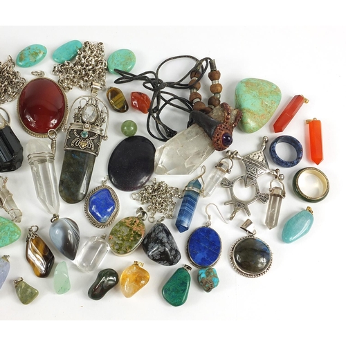 876 - Selection of spiritual healing crystal pendants and stones, some with silver mounts