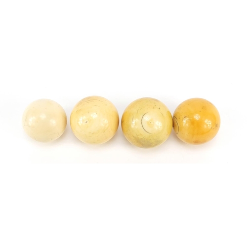 1125 - Four turned ivory billiard balls, the largest approximately 4.6cm in diameter