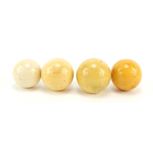 1125 - Four turned ivory billiard balls, the largest approximately 4.6cm in diameter