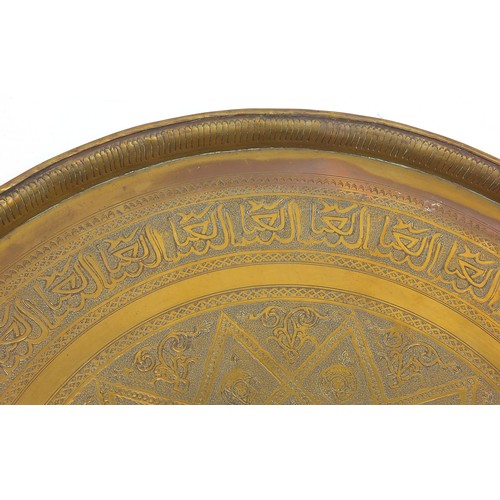 61 - Three large Islamic Cairoware brass trays engraved with calligraphy and stylised flowers, the larges... 