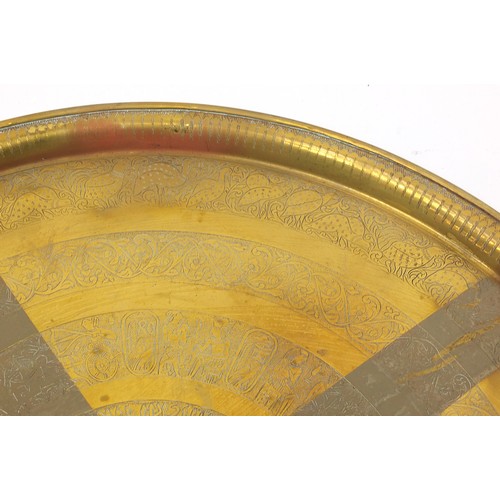 61 - Three large Islamic Cairoware brass trays engraved with calligraphy and stylised flowers, the larges... 