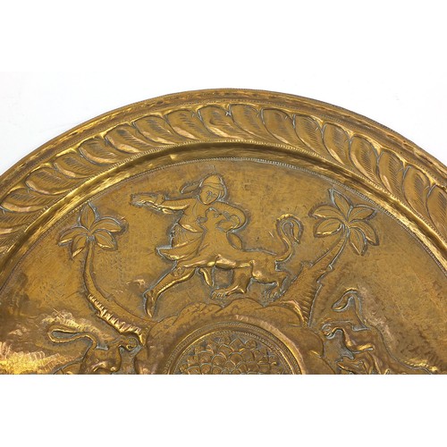 470 - Two good Indian brass trays including one finely embossed with huntsmen and wild animals, the larges... 