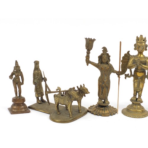 196 - Indian bronze metalware including votive figures and a pair of figural candlesticks, the largest 23.... 