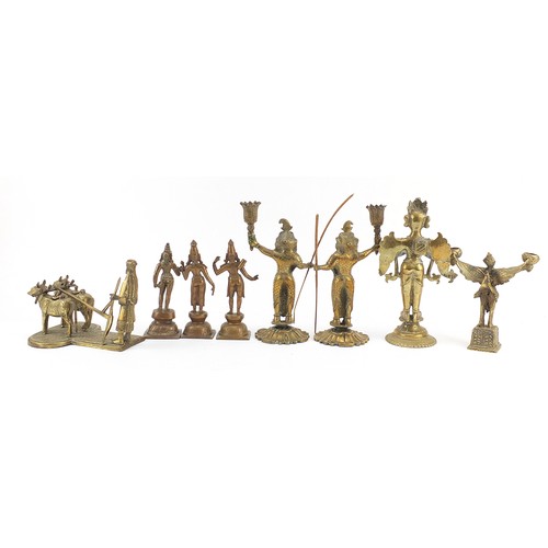 196 - Indian bronze metalware including votive figures and a pair of figural candlesticks, the largest 23.... 