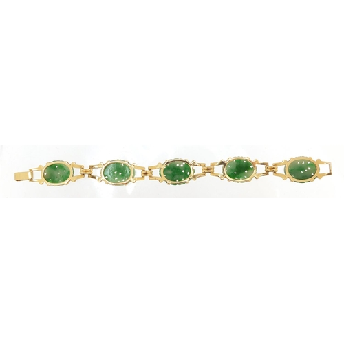 52 - Chinese 14ct gold and green jade bracelet having five oval panels carved with flower heads, 17cm in ... 