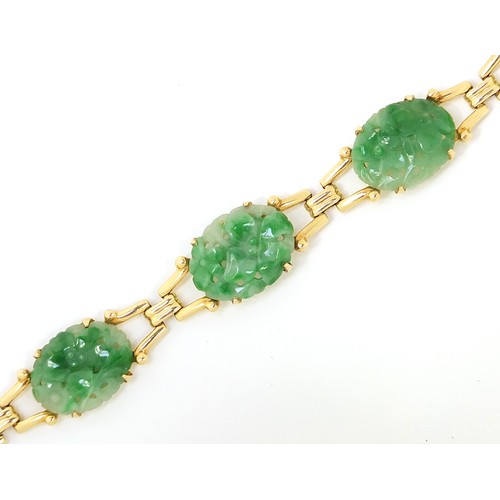 52 - Chinese 14ct gold and green jade bracelet having five oval panels carved with flower heads, 17cm in ... 