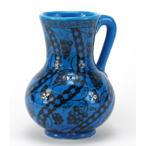 1928 - Islamic pottery vase with handle hand painted with stylised flowers, script to the base, 22cm high