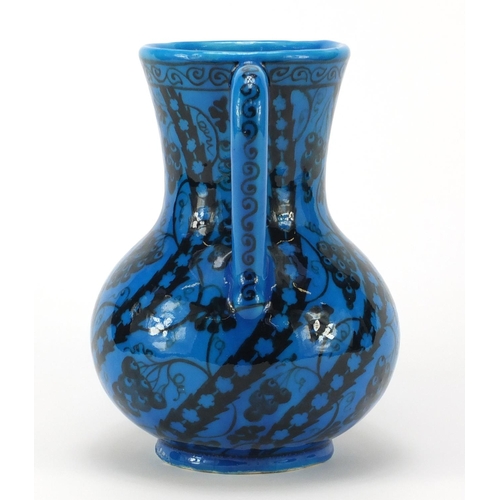 1928 - Islamic pottery vase with handle hand painted with stylised flowers, script to the base, 22cm high