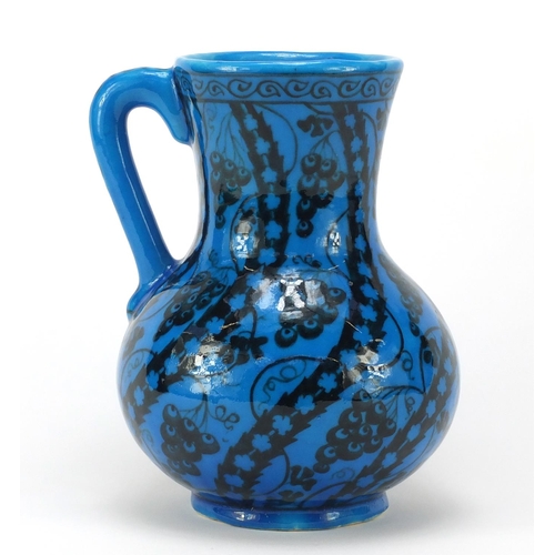 1928 - Islamic pottery vase with handle hand painted with stylised flowers, script to the base, 22cm high