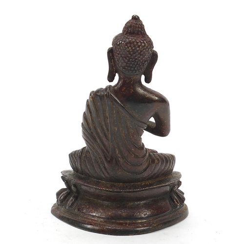 69 - Chino-Tibetan partially gilt bronze figure of seated Buddha with remnants of red paint 15.5cm high