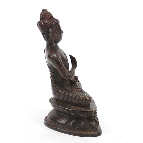 69 - Chino-Tibetan partially gilt bronze figure of seated Buddha with remnants of red paint 15.5cm high