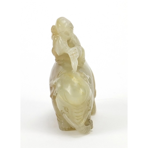 250 - Chinese celadon and russet jade carving of a boy holding a ruyi sceptre on elephant, 6.5cm wide