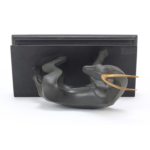 109 - Modernist patinated bronze study of a stylised gazelle raised on a rectangular block base with plaqu... 