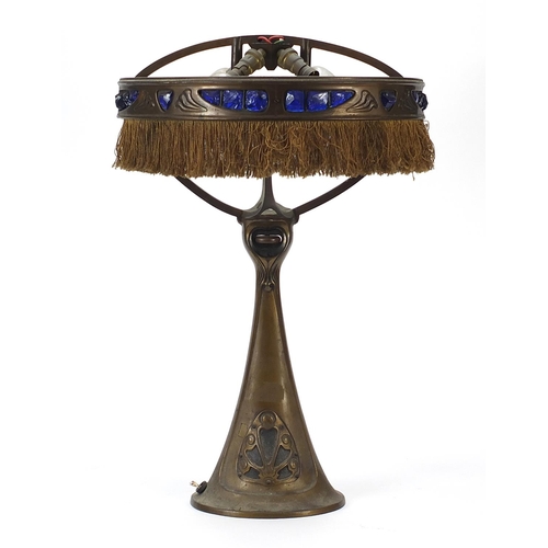 110 - Art Nouveau patinated bronze table lamp with blue rough cut stone type mounts and remnants of leathe... 