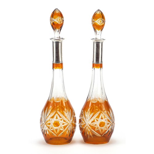 296 - Pair of Bohemian amber flashed cut glass decanters with silver collars, each 43cm high