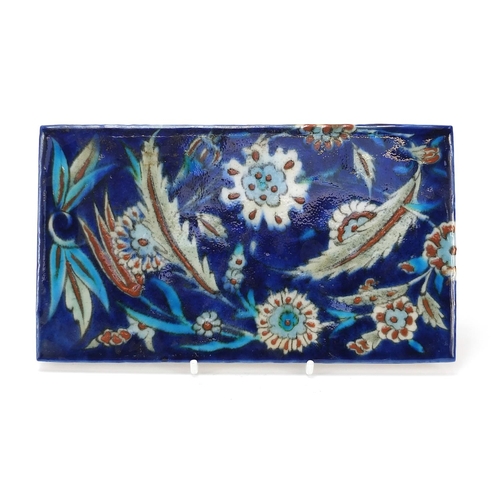 128 - Turkish Iznik tile fragment hand painted with flowers and foliage, 21cm x 12cm