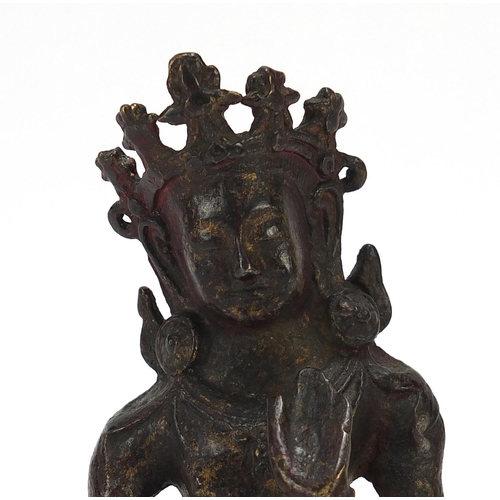 115 - Chino Tibetan bronze figure of Buddha with remnants of gilding and red paint, 15cm high