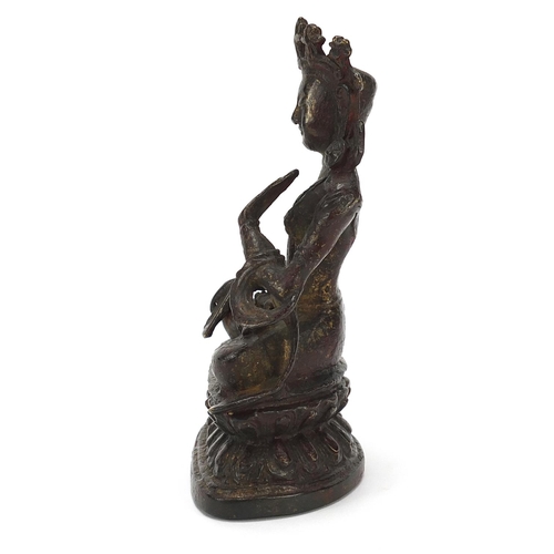 115 - Chino Tibetan bronze figure of Buddha with remnants of gilding and red paint, 15cm high