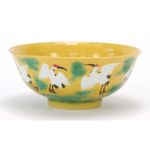 822 - Chinese porcelain yellow and aubergine bowl hand painted with cranes amongst clouds above crashing w... 