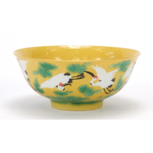 822 - Chinese porcelain yellow and aubergine bowl hand painted with cranes amongst clouds above crashing w... 