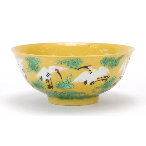 822 - Chinese porcelain yellow and aubergine bowl hand painted with cranes amongst clouds above crashing w... 