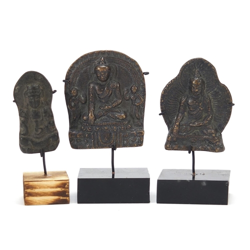 401 - Three Nepalese patinated bronze plaques of Buddha with display stands, the largest 11cm high