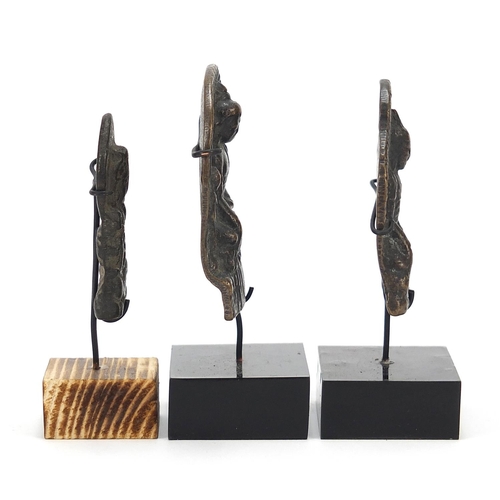 401 - Three Nepalese patinated bronze plaques of Buddha with display stands, the largest 11cm high