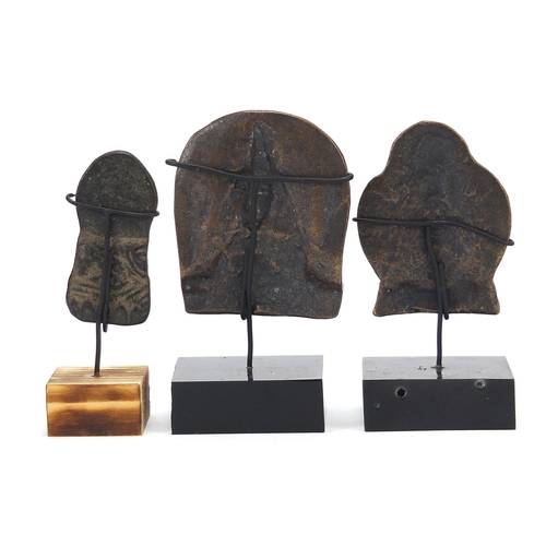 401 - Three Nepalese patinated bronze plaques of Buddha with display stands, the largest 11cm high